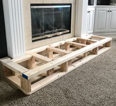 a living room with a fireplace built into the wall and some wooden pallets on the floor