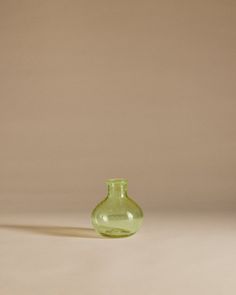 a small green vase sitting on top of a table