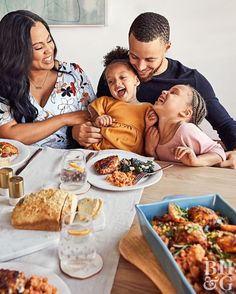 a group of people sitting around a table with food