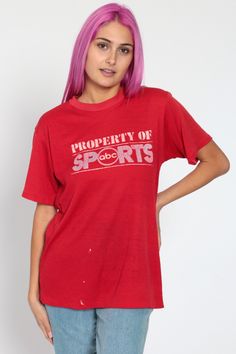 "Vintage 80s t shirt with 'Property of ABC Sports' on the front. Every garment we sell is authentic vintage and one-of-a-kind! You will receive the exact item photographed. Condition: Worn-in. Has some paint marks and large runs in the fabric. Some loose threads along the hemline Best fits women's: Medium Best fits men's: Small Material: Cotton / polyester blend MEASUREMENTS Taken from seam to seam while the garment is lying flat. Double the armpit, waist, and hips For reference, model is 5'7\" 80s Tshirts, Red Graphic Tee, Babydoll Dress Grunge, Grunge Dress 90s, Animal Sweater, Leaves Print Dresses, Sports Shirt, Usa Shirt, Vintage Tee