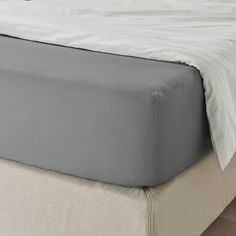 a close up view of a bed with white sheets