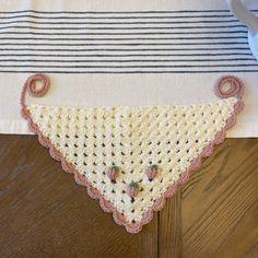 a crocheted triangle on top of a wooden table