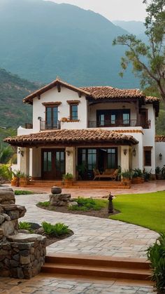 a large white house sitting on top of a lush green hillside