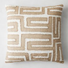 a brown and white pillow on a white wall