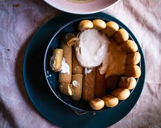 a blue plate topped with food next to a bowl filled with sauce and marshmallows