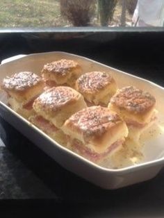 some small sandwiches in a white dish on a table