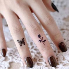 a woman's hand with a small butterfly tattoo on her left thumb and finger