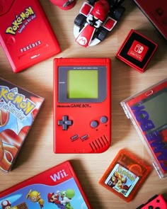 an assortment of nintendo games and accessories laid out on a wooden table with the gameboy