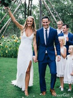 a bride and groom are walking with their flower girls down the aisle in front of them