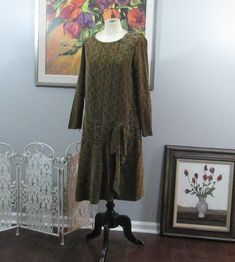 This is a vintage day dress from the 1920's. It is velvet with a muted orange and green pattern throughout. Dropped waist with bow at the left side. Bow at the left shoulder. Unlined. No fasteners; it just pulls on . This does have a label inside that someone has placed showing who this dress belonged to, but I'm not including that for privacy reasons. The label is adhesive and can be pulled out easily. Fits up to a 38" bust, waist and hips as it is a straight style. Length is about  39" from to 1920s Day Dress, Vintage Day Dress, Muted Orange, Princess Wedding Gown, Orange And Green, Princess Wedding, Green Pattern, Day Dress, Green Velvet