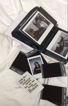 several polaroid photos are laying on top of a white sheet with black border around them