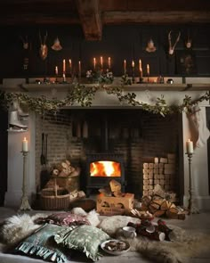 a fireplace with candles, blankets and other items in front of it on the floor