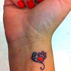 a woman's wrist with a dog paw and heart tattoo on the left hand