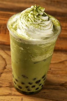 a green drink with whipped cream and sprinkles