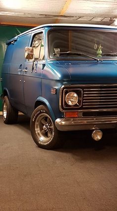 an old blue van parked in a garage