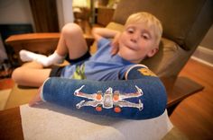 a young boy sitting in a chair with his foot up on the armrests