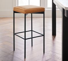 a bar stool sitting on top of a hard wood floor next to a countertop