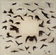 a group of black birds flying in the air over a white square with squares on it