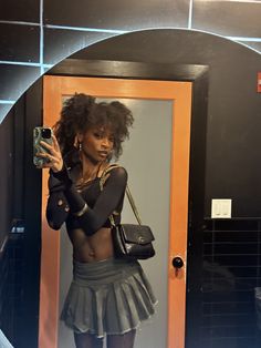 a woman taking a selfie in front of a mirror wearing a skirt and heels