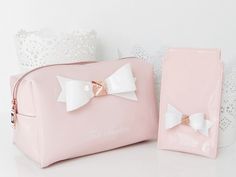 two pink bags with white bows on the front and one has a small purse in the back