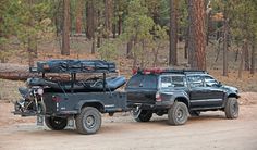 two vehicles parked on the side of a dirt road