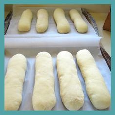 six loaves of bread sitting on top of a white paper lined baking pans