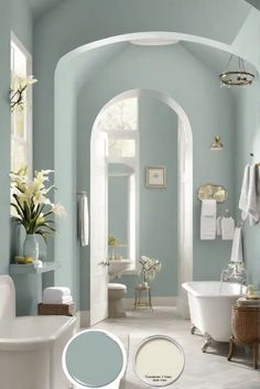 a bathroom with blue walls and white fixtures, including a claw foot tub in the center