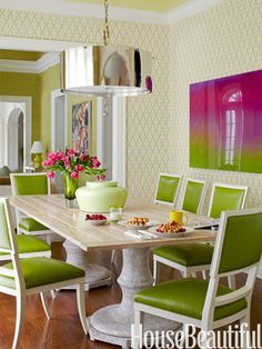 a dining room with green chairs and a white table in the middle of the room