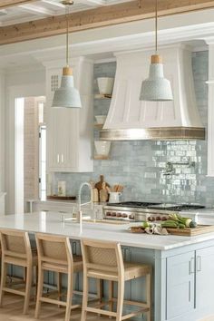 a kitchen with an island and several stools in front of the counter top area