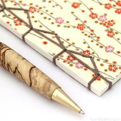 a pen sitting on top of a piece of paper next to a small wooden object