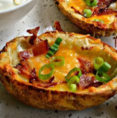 two baked potatoes with bacon and green onions