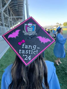 a person wearing a graduation cap that says fang tastic on the side of their head