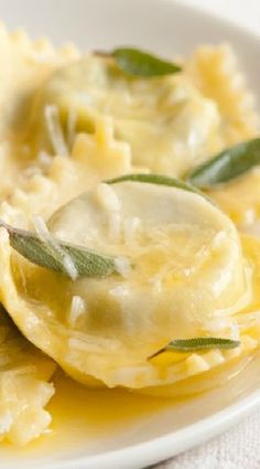 ravioli with cheese and sage leaves on a white plate