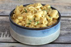 a bowl filled with macaroni and cheese on top of a wooden table