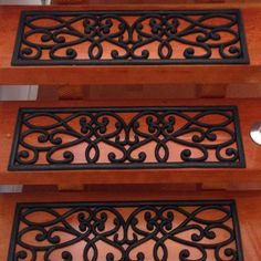 the stair treads are made from wood and wrought iron, with decorative designs on them