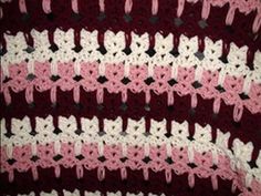 a crocheted blanket with pink and white bows