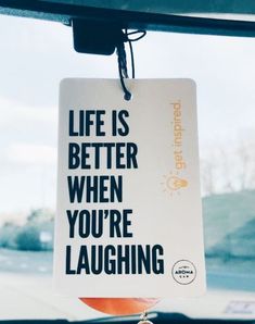 a sign that says life is better when you're laughing hanging from the windshield