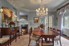 a formal dining room with chandelier and fireplace