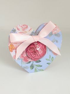 a heart shaped box with a pink bow on it