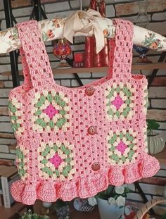 a pink crocheted purse hanging from a rack