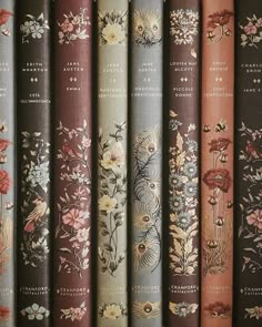 a row of books sitting on top of each other in front of a wall filled with flowers