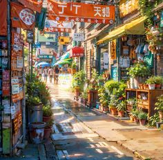 an alley way with lots of plants and signs on the buildings above it's shops