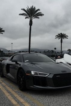 an audi sports car parked on the side of the road with palm trees in the background