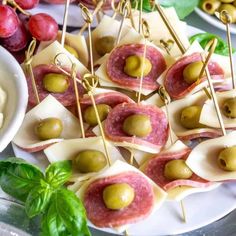 small appetizers with olives, ham and cheese are on a platter