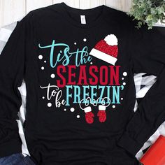 a t - shirt that says tis the season to be frozen with santa's hat