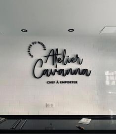 the sign for atelier cavaninn is displayed in front of a white tiled wall