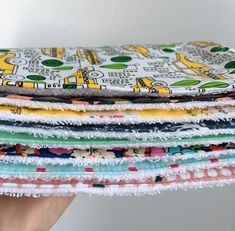 a stack of multicolored cloths being held up by someone's hand