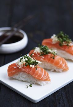 three pieces of sushi on a white plate