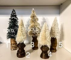 four small christmas trees sitting on top of a table