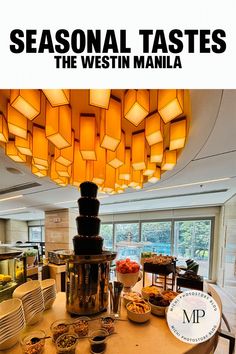 a table with plates and bowls on it in front of a large chandelier that reads seasonal tastes the westin manila